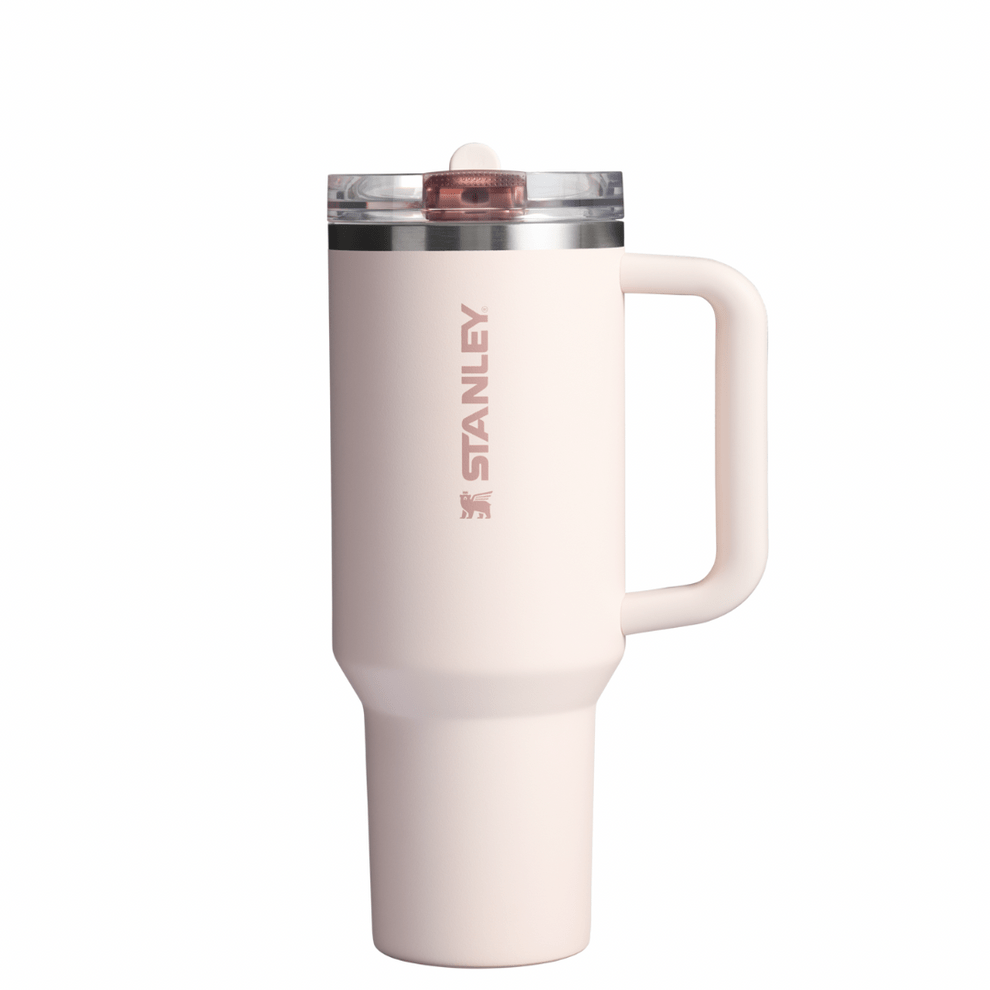 A white STANLEY branded flip straw tumbler with a clear lid and a handle.