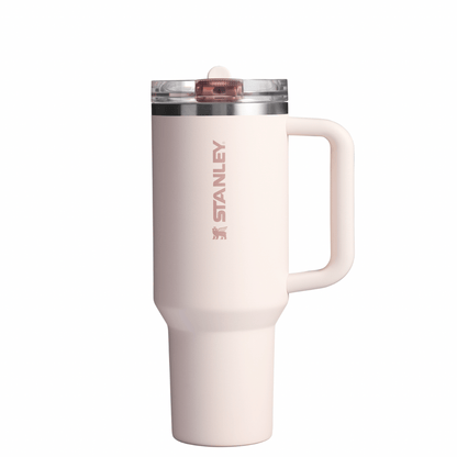 A white STANLEY branded flip straw tumbler with a clear lid and a handle.